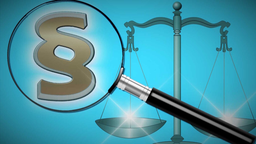Online Casino Vergleich: Anbieter, Lizenz, Spielerschutz und Auszahlungsbedingungen richtig bewerten 29 Das Bild zeigt einen Paragraphen und eine Lupe die darstellen sollten, dass Gesetze bei einem Online Casino Vergleich berücksichtigt werden sollten.